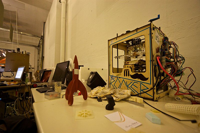 A stuffed desk with 3D prints and a Makerbot.